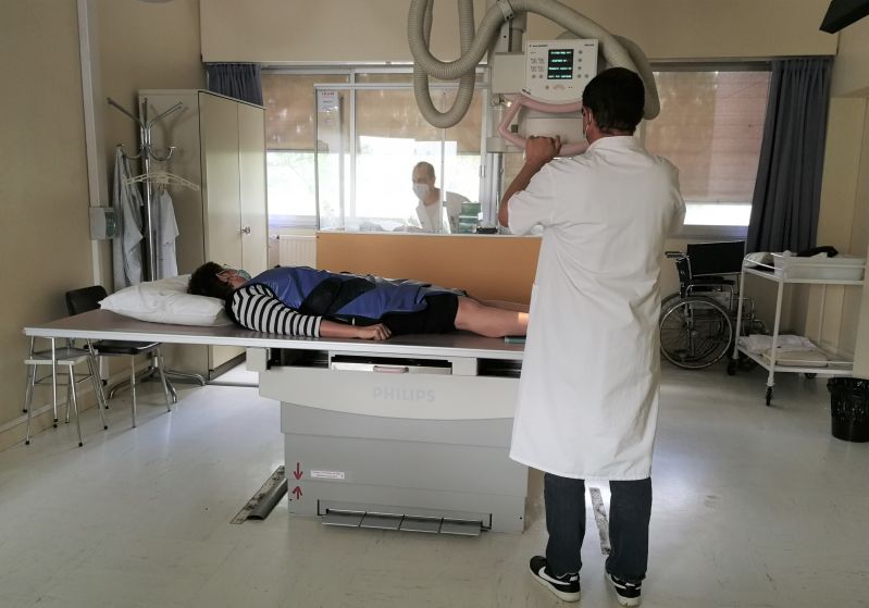 Salle de simulation radiologique avec un étudiant réalisant un radiographie à un patient